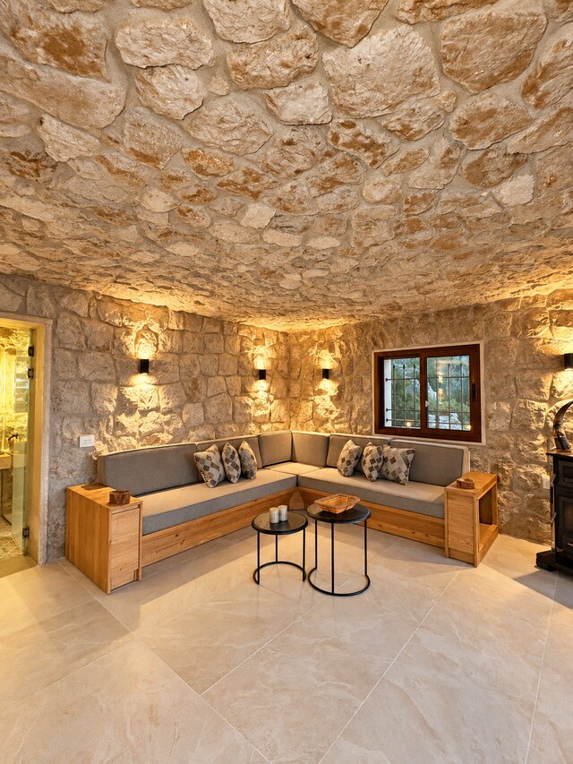 La Grande's corner sofa under the vaulted stone ceiling, with a low table and a window onto the terrace.