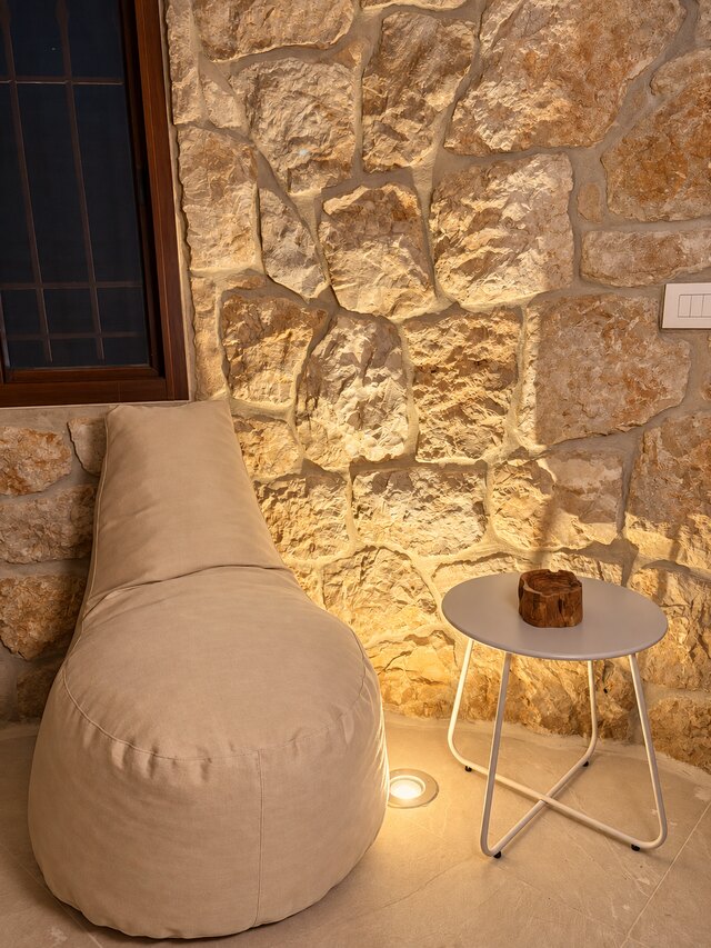A reading corner in La Grotta: a bean bag chair against the rock wall next to the window and a small side table.