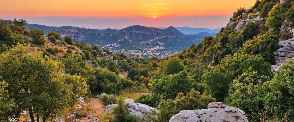 The marked trail leading down from the ridge toward the Douma valley at sunset.