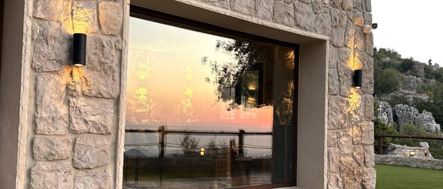 La fenêtre de La Grande au crépuscule, la vallée captant les dernières lueurs derrière la vitre.